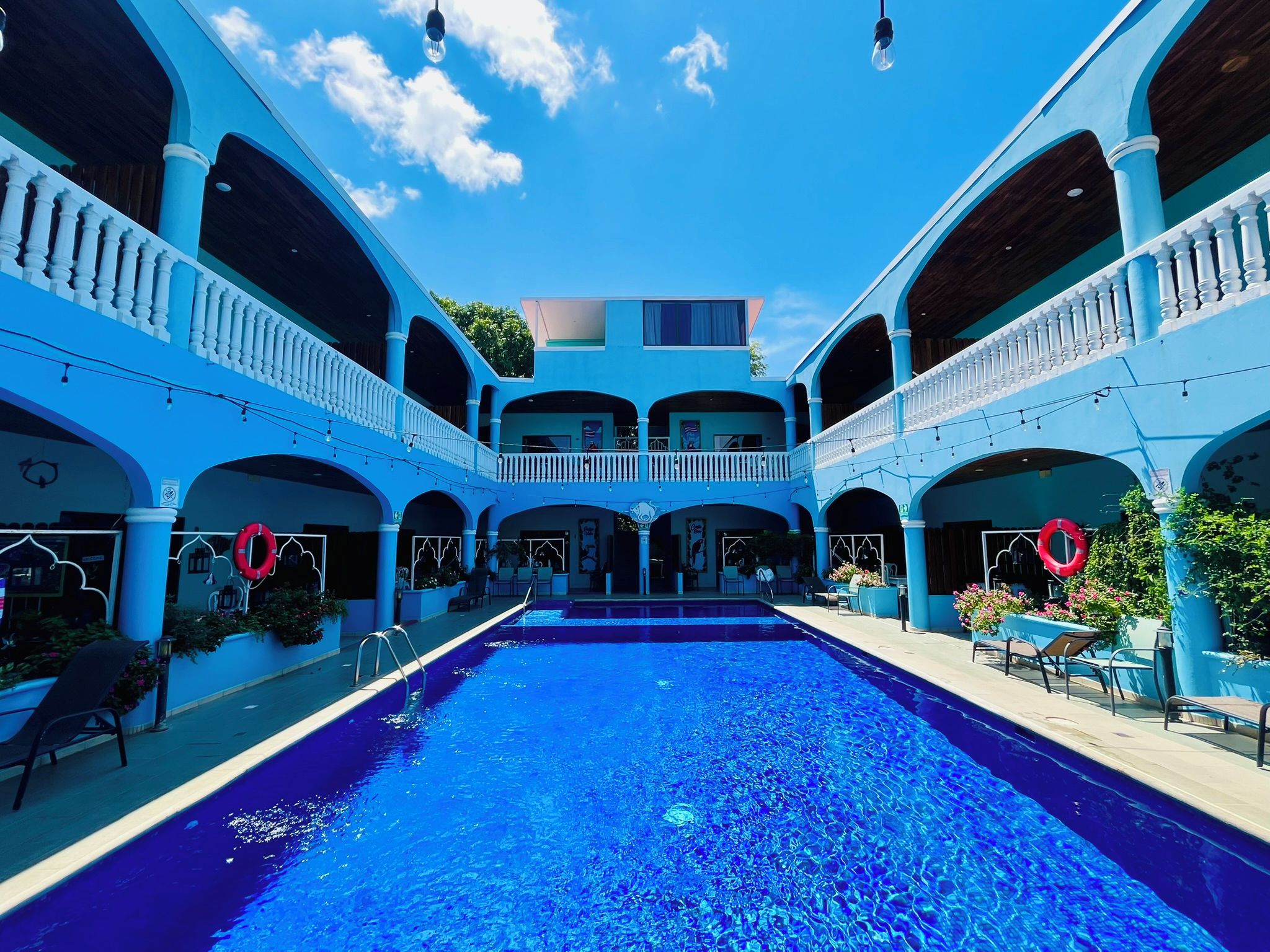 A large indoor swimming pool with multiple levels of balconies and seating areas.