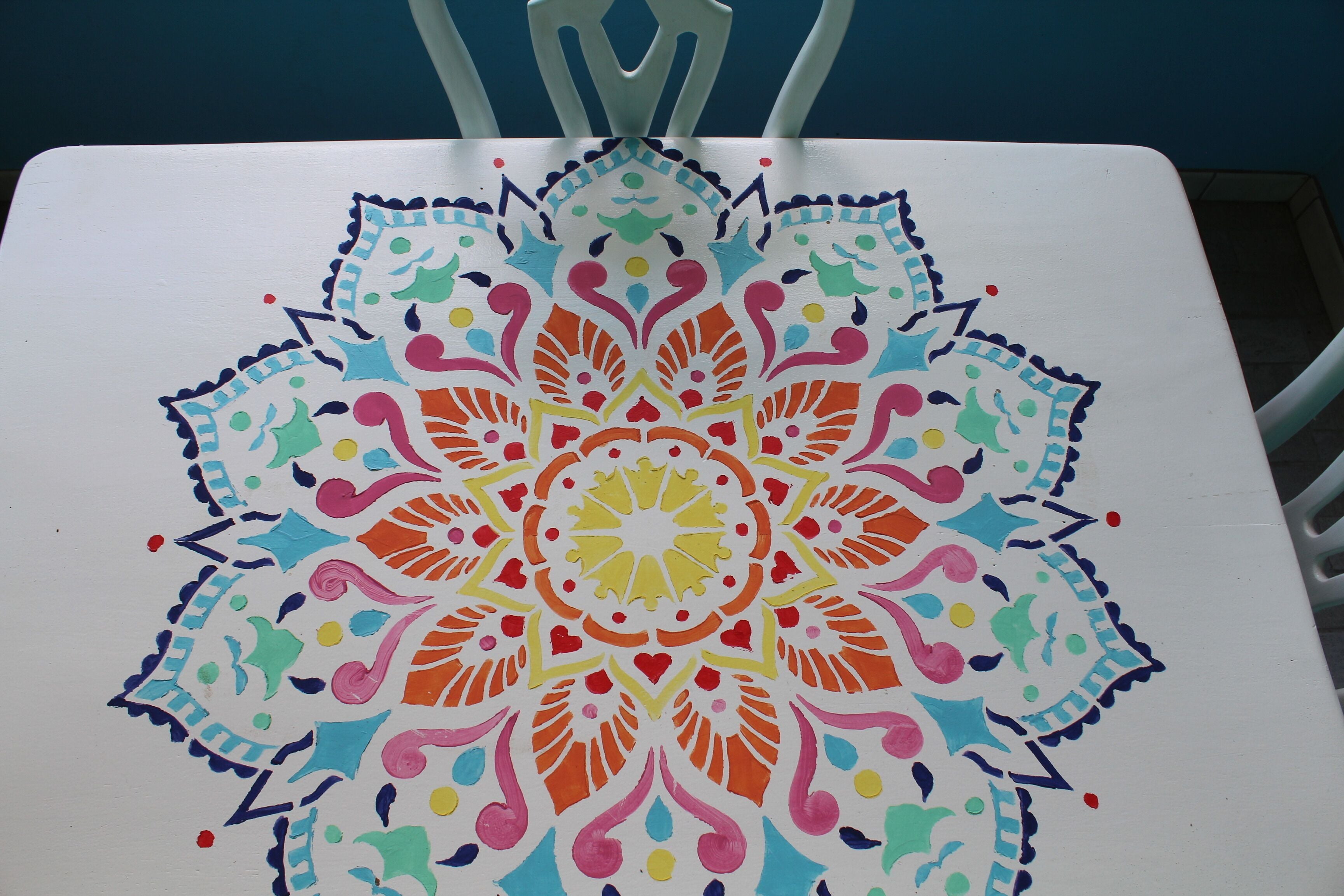 Un tavolo bianco con un design mandala colorato.