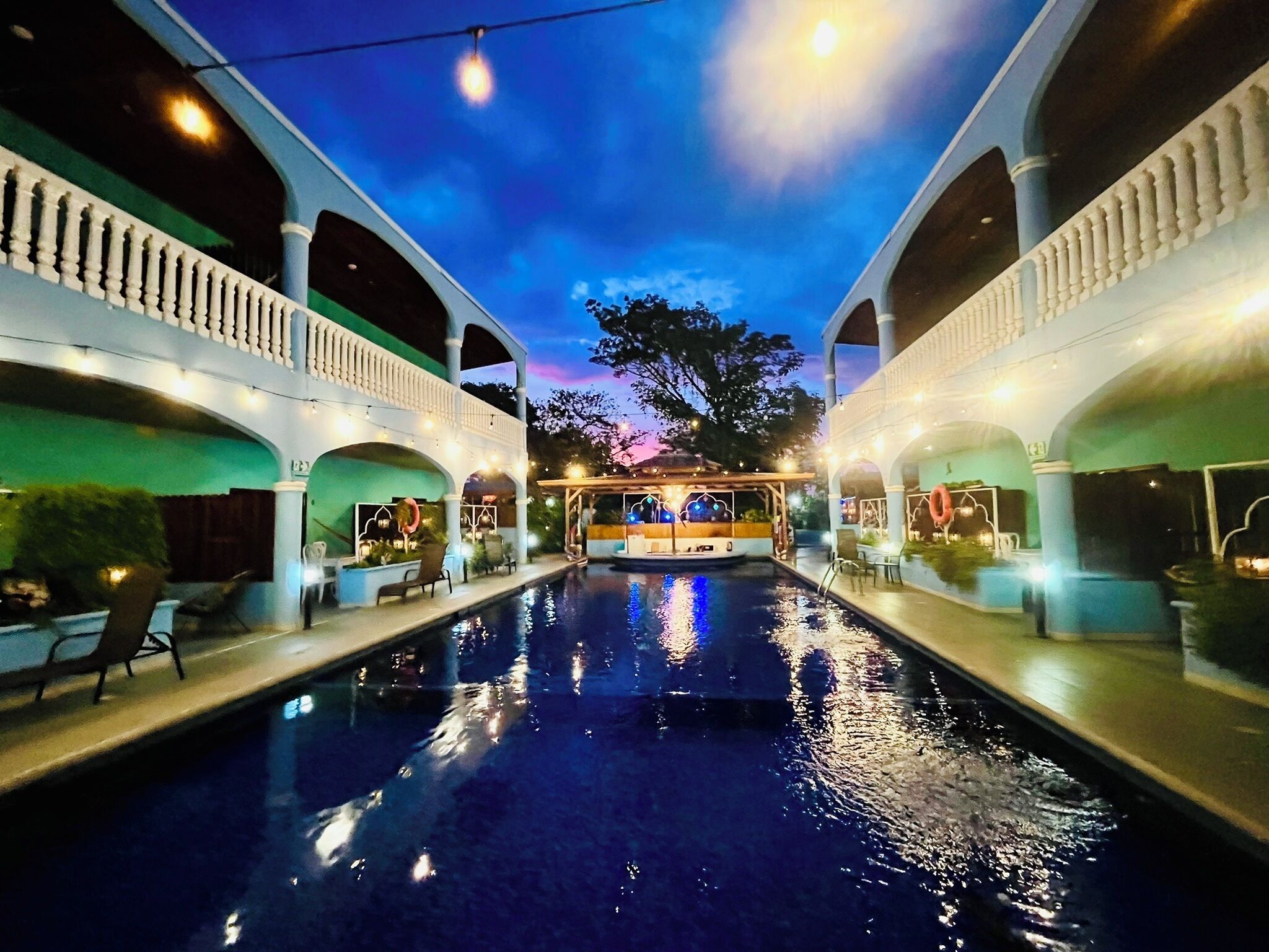 Piscina con vista al cielo y un edificio al fondo.