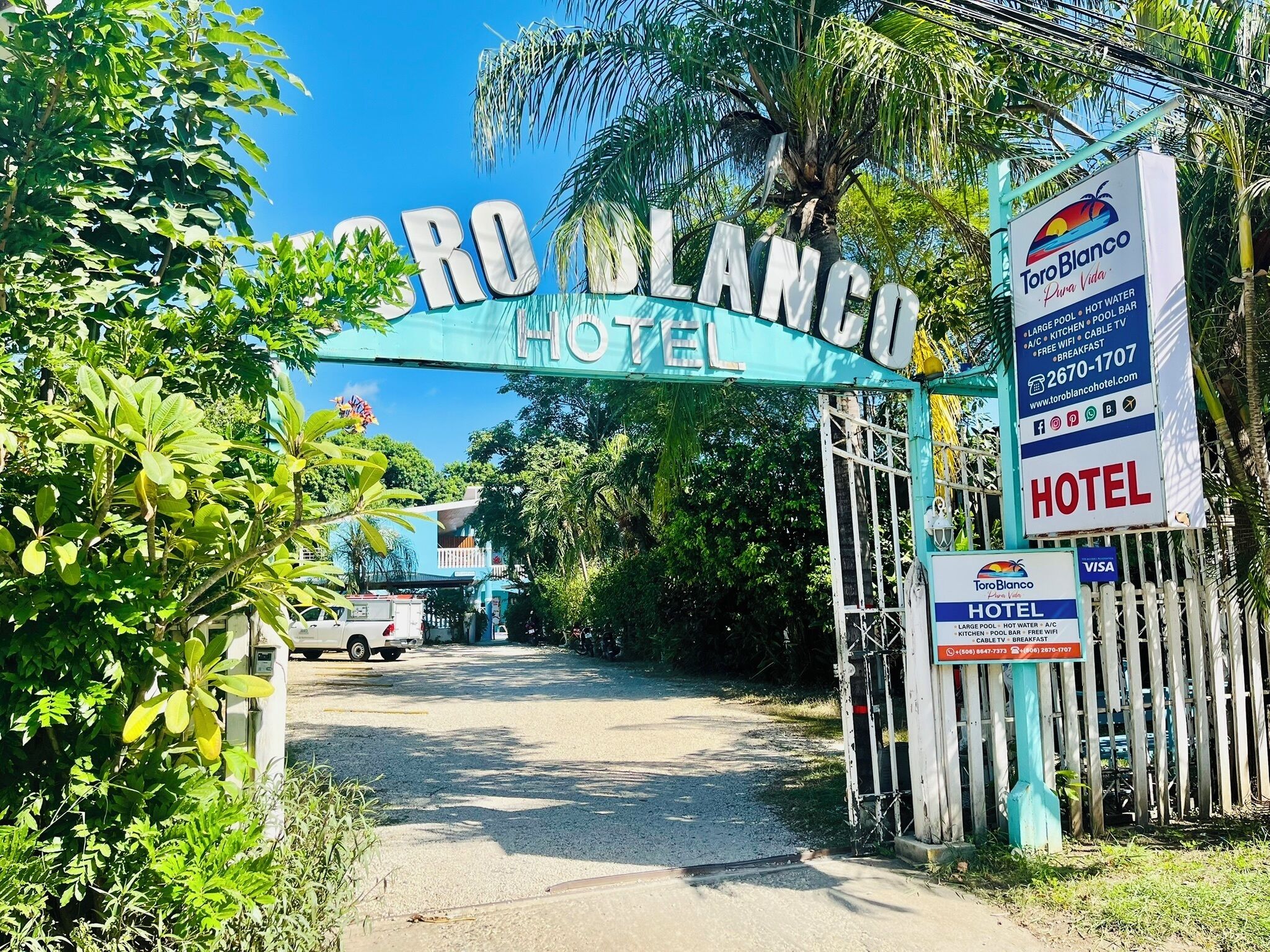 De ingang van Hotel Toro Blanco, met een bord waarop voorzieningen en contactgegevens staan.