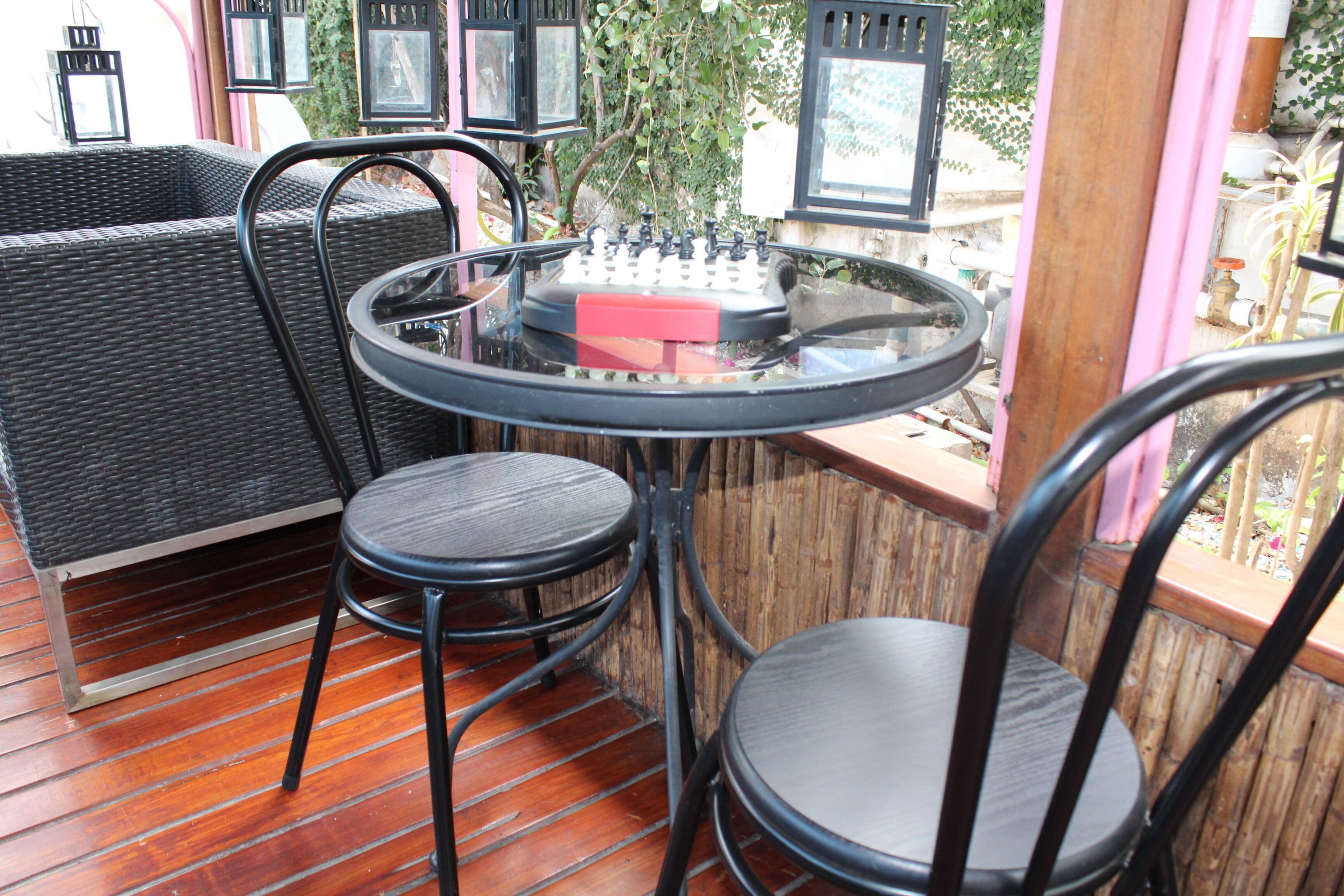 A patio area with wicker furniture, a round table, and two chairs.