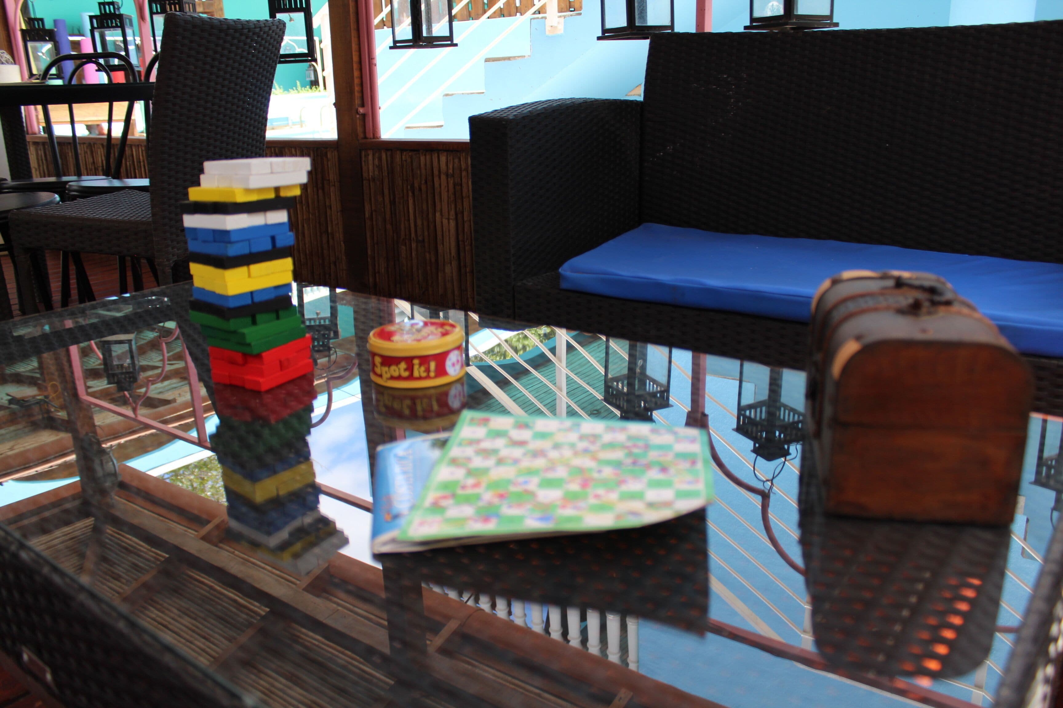 A glass table with a Rubik's cube, a board game, and a toy train.