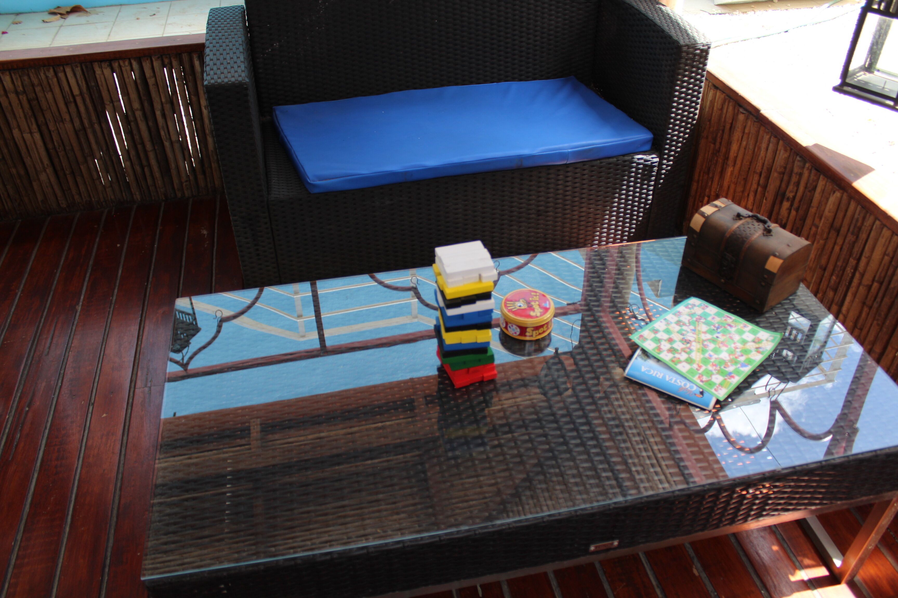 A glass-top table with a chessboard, a stack of colorful blocks, and a small toy train.