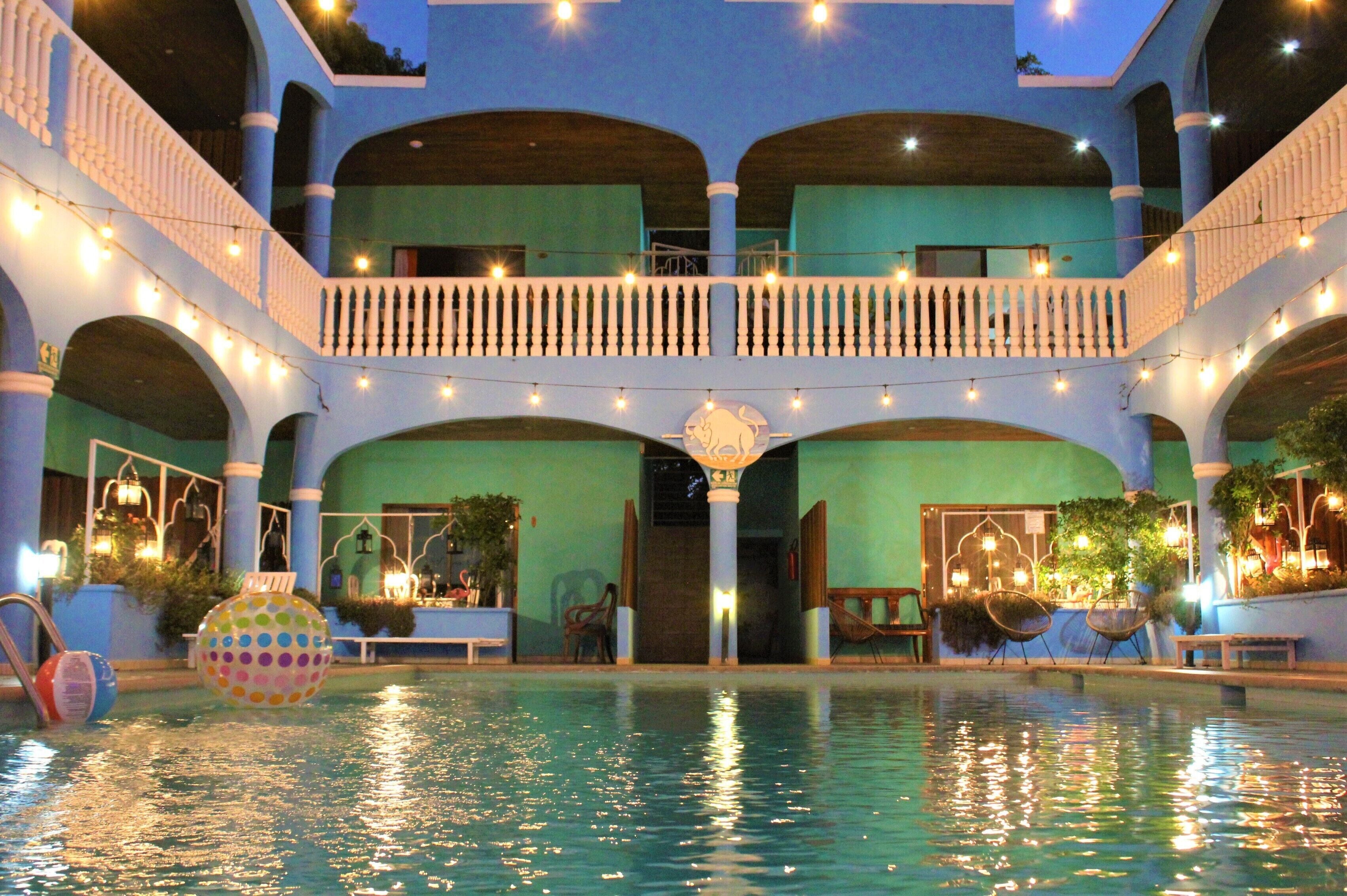 Un área de piscina con varios niveles, luces de cadena, un globo decorativo y asientos alrededor de la piscina.