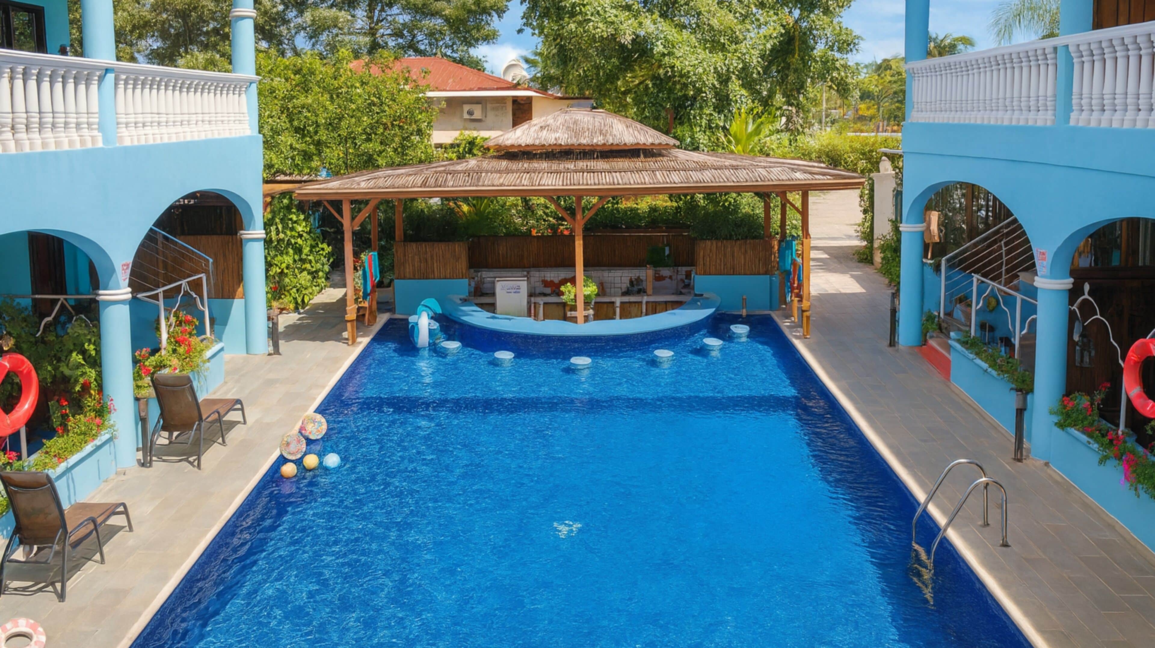 A swimming pool with a covered area, lounge chairs, and a bar.