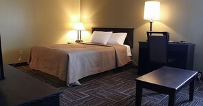 A hotel room with a bed, two bedside lamps, a desk, and a chair.