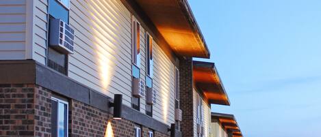 A row of brick buildings with multiple windows and a covered walkway.