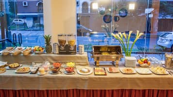 A buffet table with various food items and a buffet station.