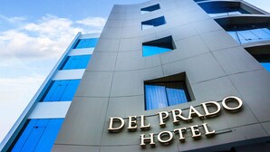 The exterior of the Del Prado Hotel with a modern design, featuring large windows and a prominent sign. - Del Prado Hotel (Lima)