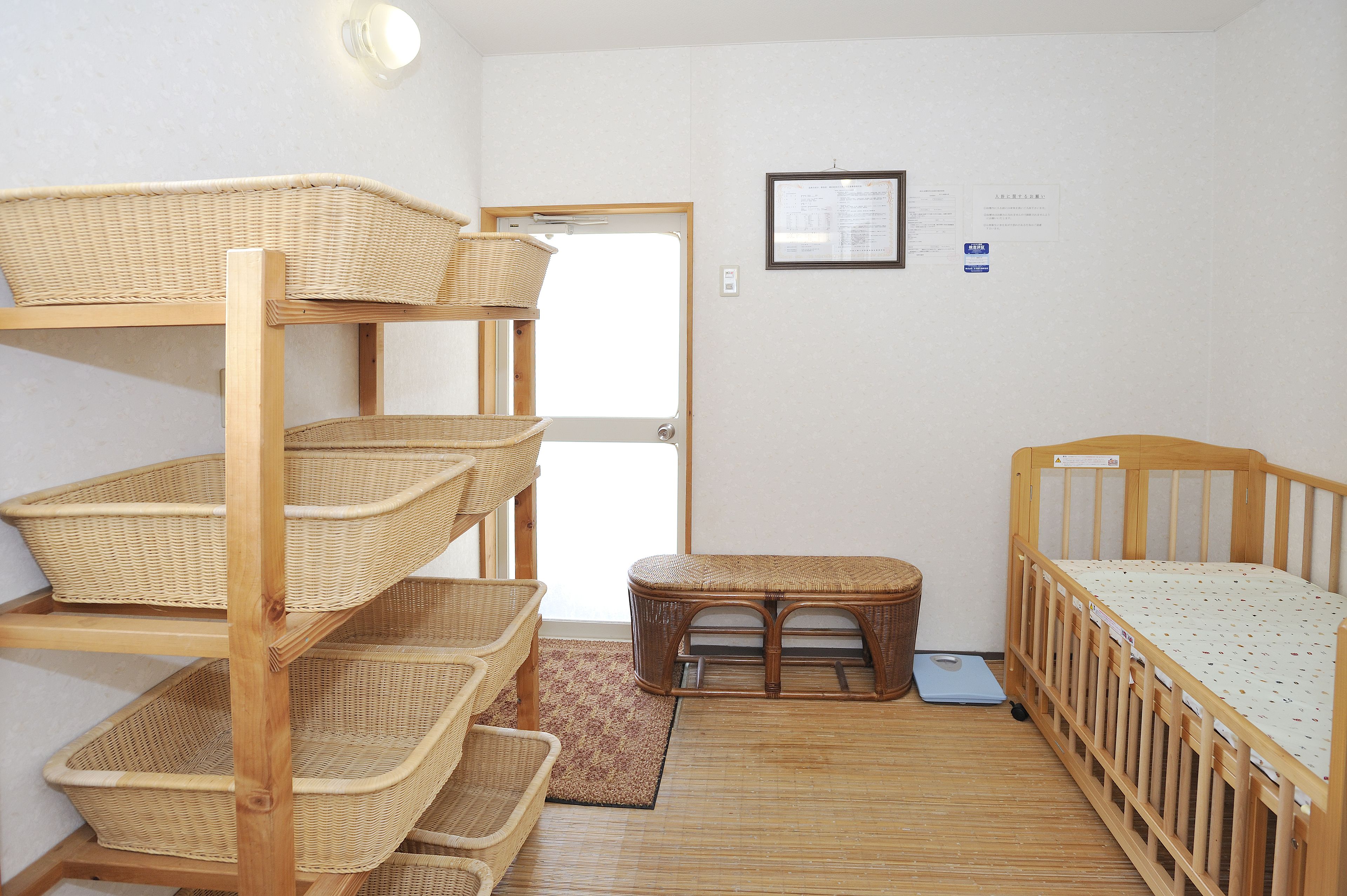 Una habitación con una litera, un taburete pequeño y varios cestos de mimbre en estantes.