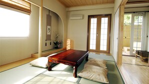 A traditional Japanese room with tatami flooring, a low wooden table, and sliding doors. - Hotel Chobo Sanso (Yugawara)