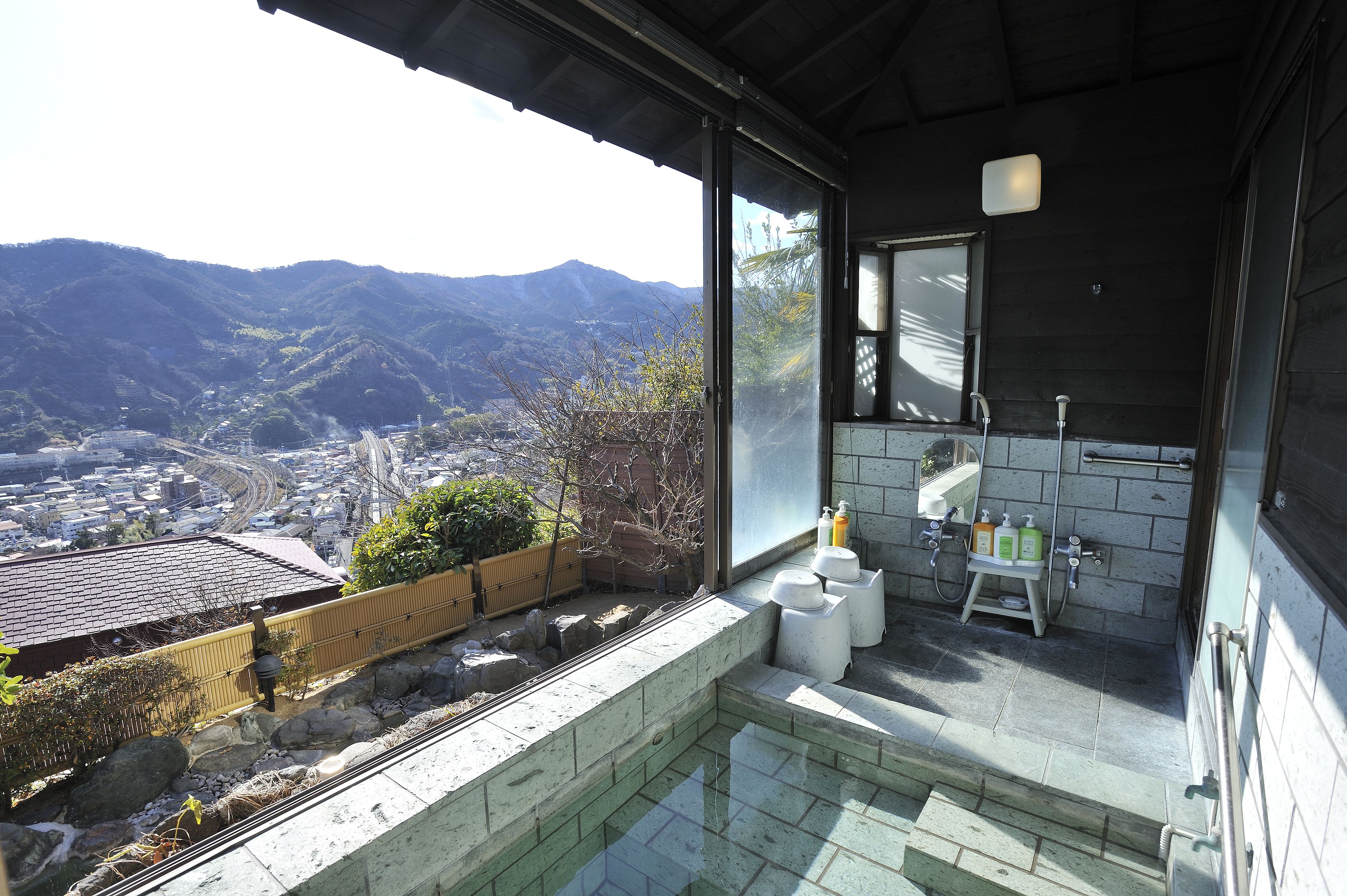 A bathroom with a view of mountains, a small sink, and toiletries.