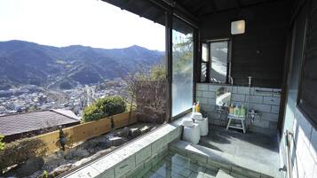A bathroom with a view of mountains, a small sink, and toiletries.