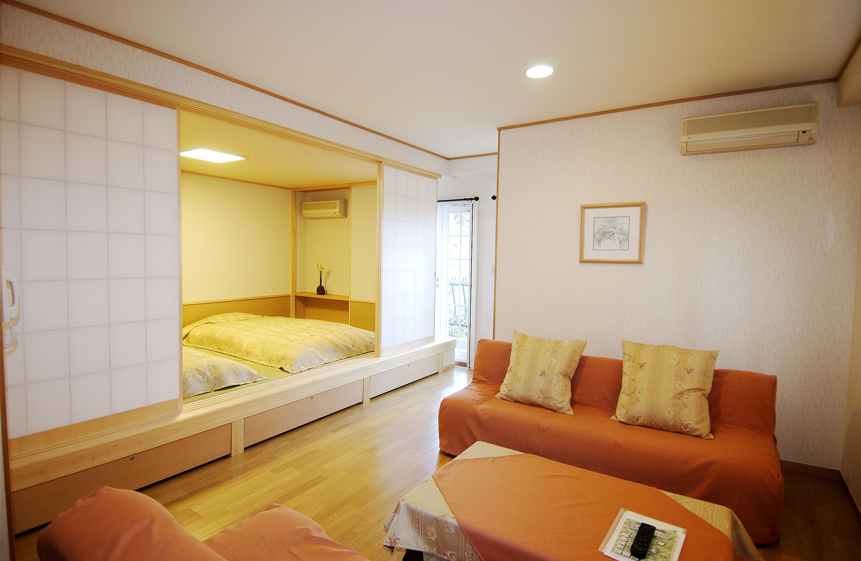 A compact room with a bed, a sofa, and a small table.