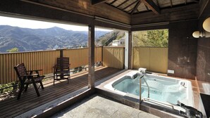 A wooden deck with a hot tub and chairs overlooking a mountainous landscape. - Hotel Chobo Sanso (Yugawara)