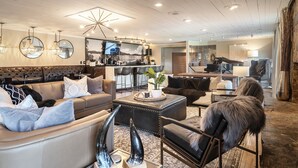 A spacious living area with a leather sofa, a coffee table, and a fireplace. - Black Forest Inn Bed & Breakfast (Rapid City)
