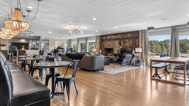 A spacious living area with a fireplace, wooden flooring, and modern furniture. - Black Forest Inn Bed & Breakfast (Rapid City)