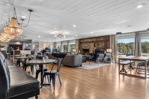 Amplia sala de estar con chimenea, piso de madera y muebles modernos.
