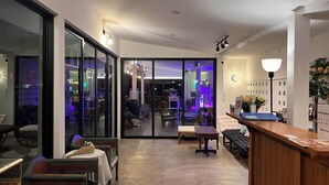Un moderno vestíbulo de hotel con mostrador de recepción, zona de estar y vista al comedor.