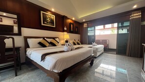 Habitación de hotel con dos camas, cabecero de madera, un cuadro grande, una lámpara y vistas al exterior.