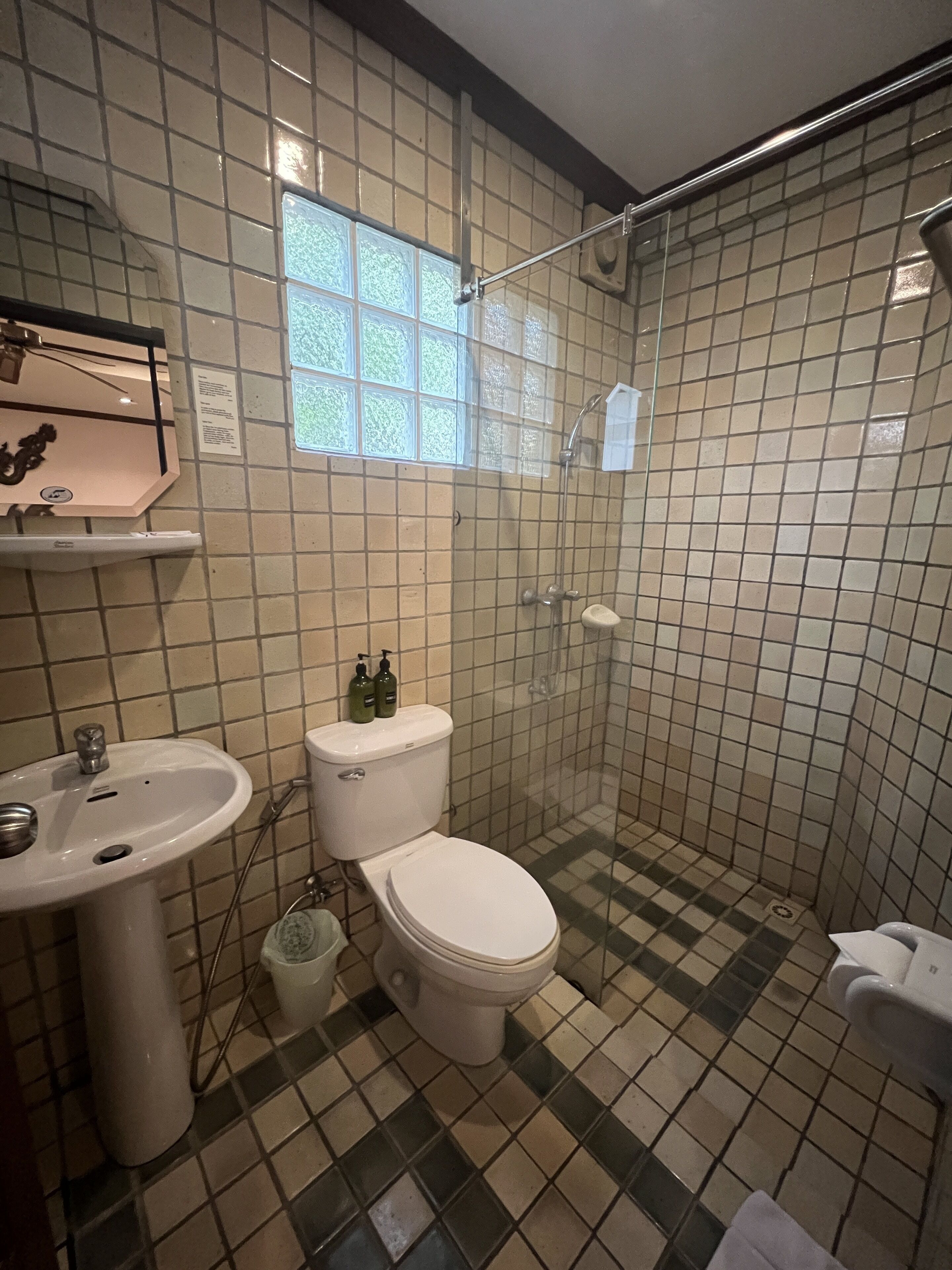 A bathroom with a toilet, sink, and shower.
