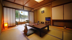 Una habitación tradicional japonesa con suelo de tatami, una mesa baja y puertas correderas.