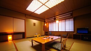 Una habitación tradicional japonesa con suelo de tatami, una mesa de madera baja y puertas correderas.