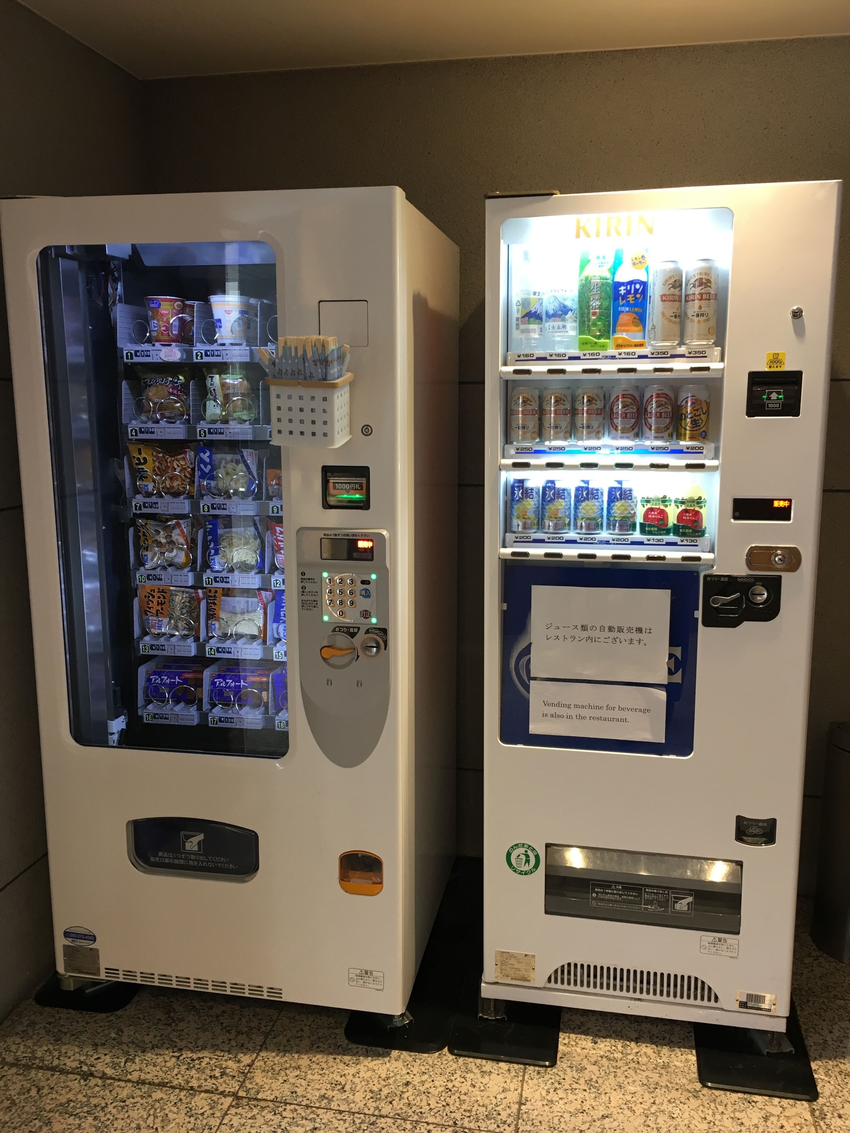 Two beverage vending machines with multiple drink options and a payment interface.