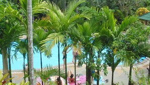 A pool area surrounded by lush tropical vegetation, with people relaxing on the edge of the pool. - Aonang Cliff Mountain New Resort (Krabi)