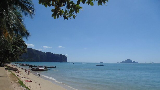 A beach with boats, clear water, and distant islands. - Aonang Cliff Mountain New Resort (Krabi)