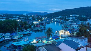 A harbor with multiple boats docked, surrounded by buildings and palm trees. - Blue Sky Phu Quoc Hotel (Phu Quoc)
