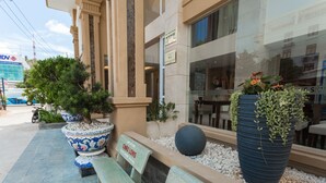 A hotel entrance with a bench, large potted plants, and a sign reading "Châu Lông". - Blue Sky Phu Quoc Hotel (Phu Quoc)