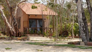 Un bâtiment doté d’un toit recouvert de tuiles rouges, entouré d’arbres et de verdure.