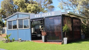 A BBQ area with a blue exterior, large windows, and a covered seating area. - Portland Retro Motel (Portland)