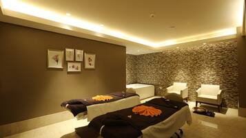 Un cuarto de spa con dos camillas de masaje, una bañera y dos sillones.