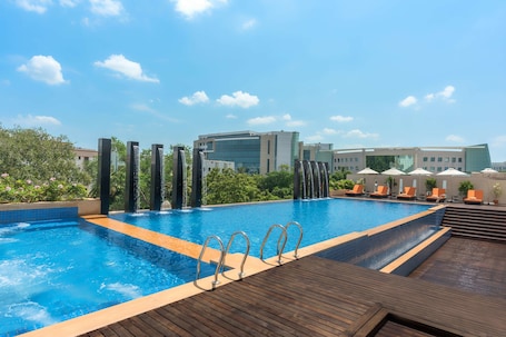 Una piscina al aire libre, sillones reclinables de piscina