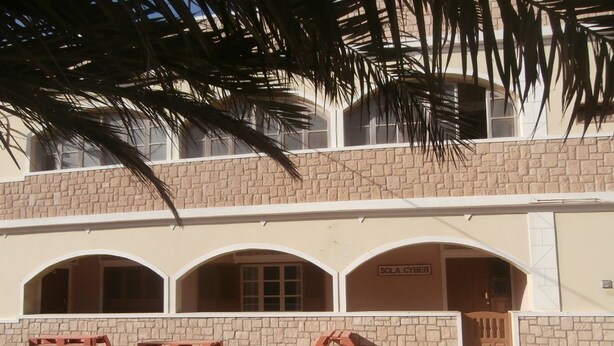A building with a stone facade, arched windows, and a sign reading "SOLA CYBER". - SolaCyber (Boa Vista)