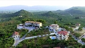 An aerial view of a residential area with multiple buildings, roads, and greenery. - Zante View Studios (Zakynthos)