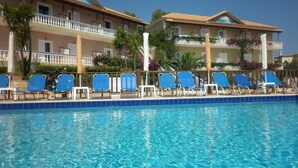 A pool area with blue lounge chairs and a clear blue pool. - Zante View Studios (Zakynthos)