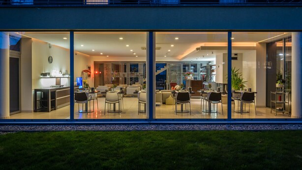 Una casa moderna con un amplio salón, una cocina y un comedor con múltiples sillas.