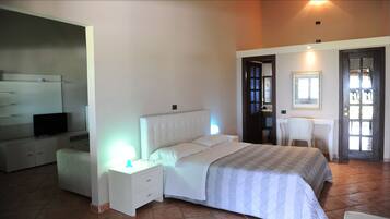 Une chambre à coucher avec un lit, des tables de chevet, une télévision, un bureau et une chaise.