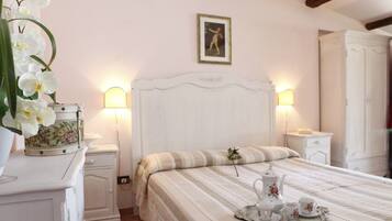 A bedroom with a bed, bedside tables, a dresser, and a wall-mounted picture.