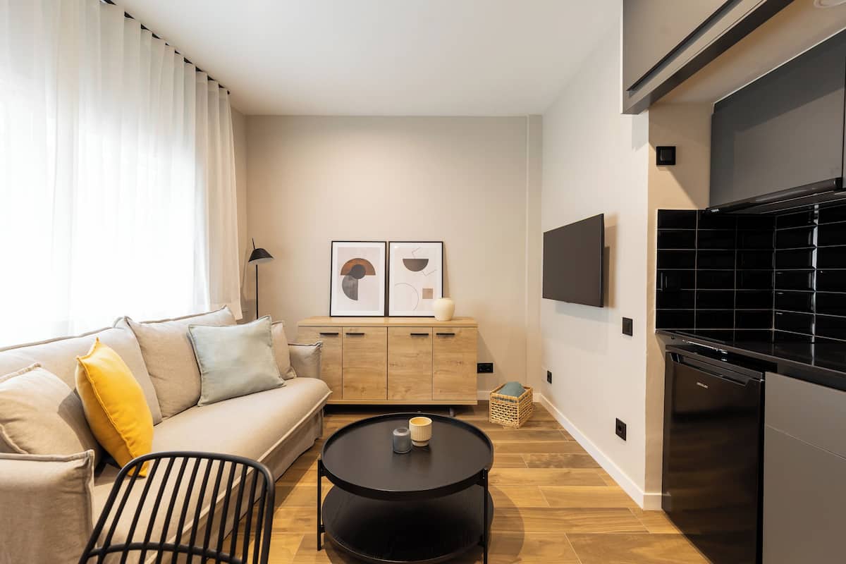 A modern living room with a sofa, a coffee table, and a TV.