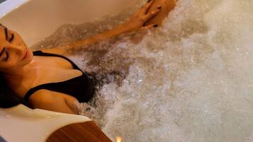 Une personne se détend dans une baignoire remplie d’eau.