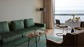 Suite, vista al mar | Área de sala de estar | Televisión de pantalla plana de 32 pulgadas con canales por cable