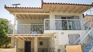 A two-story building with a balcony, stone walls, and a staircase. - Corinthian Residence (Xylokastro-Evrostina)