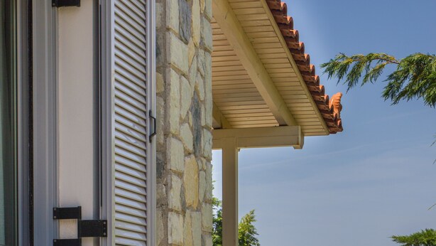 A stone building with a pool, a balcony, and a view of the sea. - Corinthian Residence (Xylokastro-Evrostina)