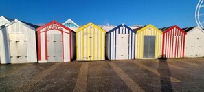 A row of colorful beach huts with a clear sky in the background. - OYO Twins Palms Guest House (Great Yarmouth)