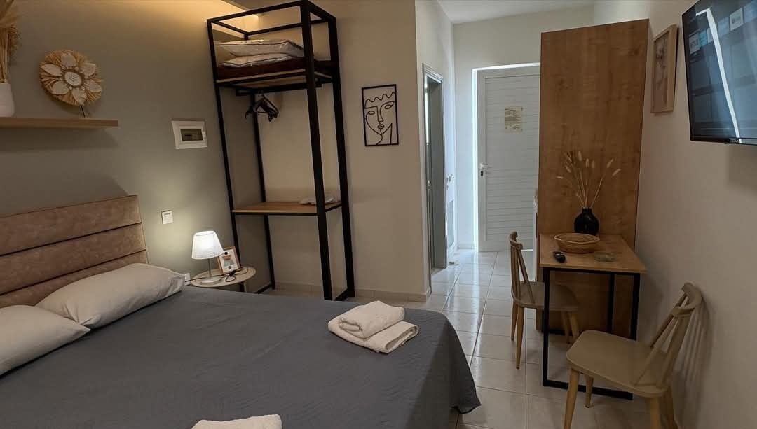 A bedroom with a bed, bedside table, lamp, and a wooden chair.