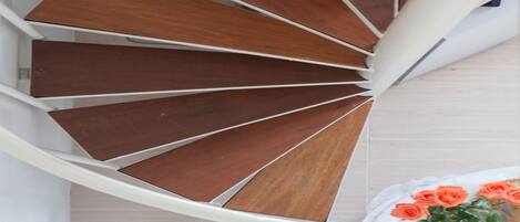 A spiral staircase with wooden steps and white railings.
